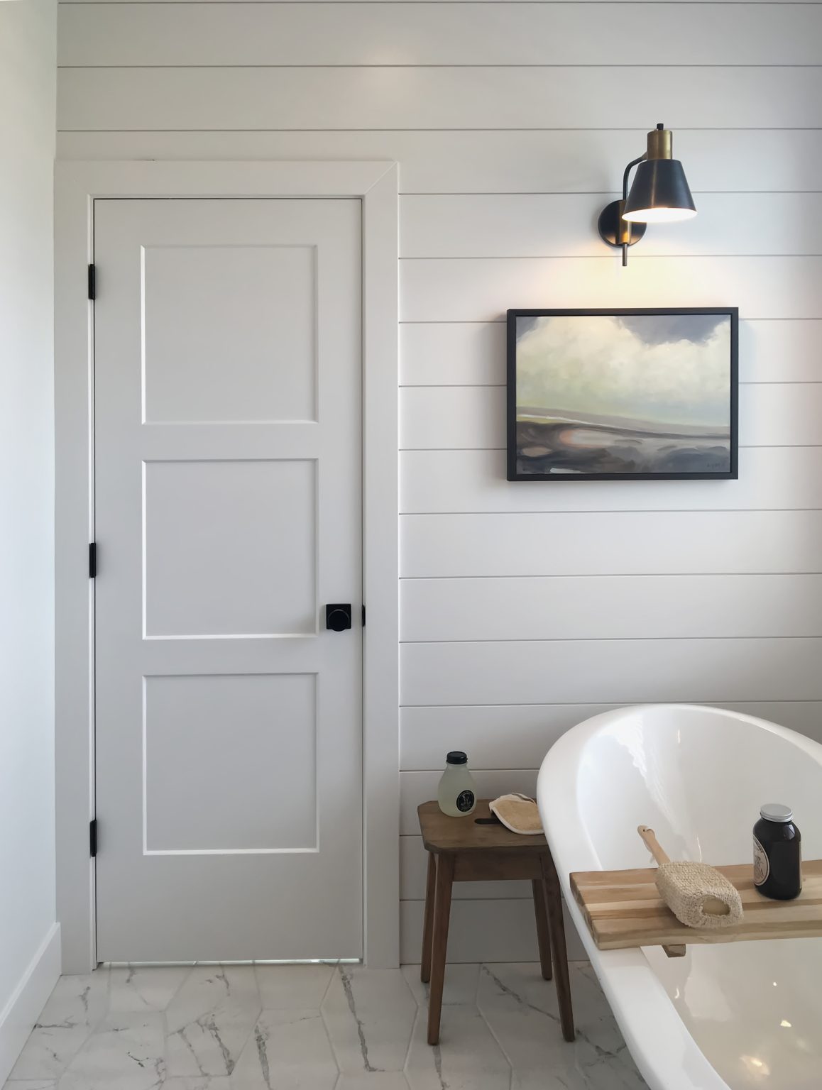 White Bathroom door with bath tub and painting
