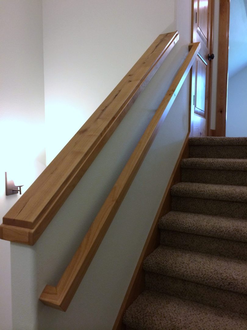 Stair way with wood handle on wall